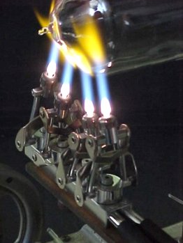 a four-port burner being used on a glass lathe